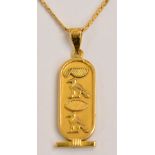 An 18ct yellow gold flat link chain supporting a yellow metal Egyptian pendant,