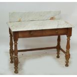 A pine washstand with marble top, two drawers, turned supports above block and turned feet,