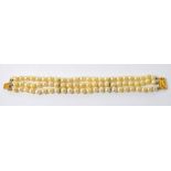 A three strand cultured pearl bracelet set with 14ct yellow gold clasp.