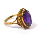 A 9ct yellow gold dress ring set with a purple stone, size L 1/2, approx 3.4g.