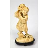 A Japanese Meiji period carved ivory okimono modelled as a two-headed figure and wearing a cloak,