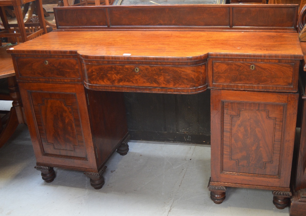 A 19th century walnut breakfast buffet with stepped shaped front and door either side of a central