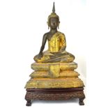 A large 19th century Chinese bronze and gilt heightened figure of Shakyamuni modelled cross-legged