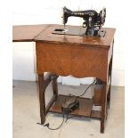 A vintage Singer sewing machine in an oak cabinet.