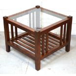 A modern square coffee table with lower slat shelf and glass top.