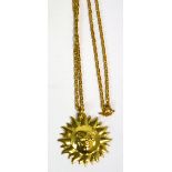A 9ct gold chain supporting a sun burst pendant,