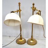 A pair of early 20th century brass adjustable table lamps with silk shades.