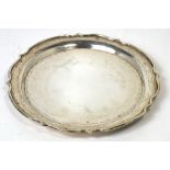 A Wing Loong sterling silver plate with shaped rim and four raised feet,