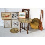 A collapsible wooden brass topped table, a decorative wall mirror, brass trays, prints,