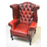 A burgundy leather Chesterfield Queen Anne style wing back chair.