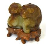 A Chinese carved celadon and russet jade group of a Dog of Fo with pup,