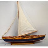 A hand made model of a whaling boat with painted hull, five oars and sail, length 85cm.