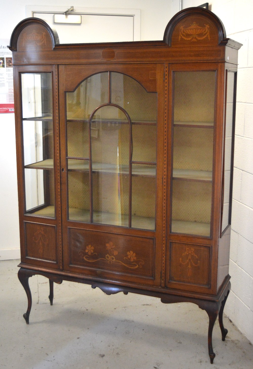 An Edwardian mahogany inlaid display cabinet with curving arch to either side over a central glass