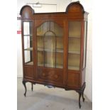 An Edwardian mahogany inlaid display cabinet with curving arch to either side over a central glass