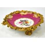 A late 19th century shallow bowl with pink ground, central vignette hand painted with roses,