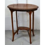 An Edwardian oval walnut side table with lower shelf supported by carved fretwork on splayed