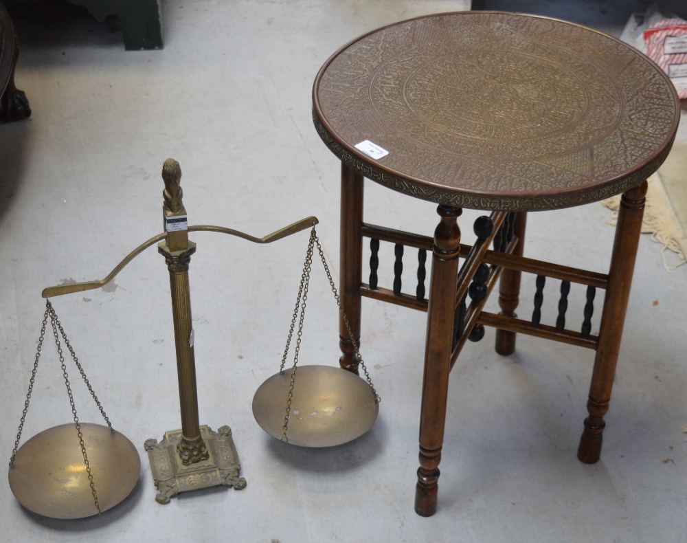 An Indian brass tabletop on a folding turned base, diameter 42cm and a vintage pair of brass scales,