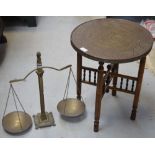 An Indian brass tabletop on a folding turned base, diameter 42cm and a vintage pair of brass scales,