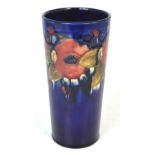 A Moorcroft cylinder vase, pomegranate pattern, on a cobalt blue base, height 21cm.