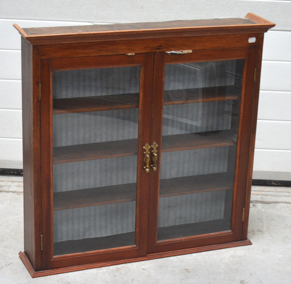 A 20th century glazed two door cabinet with interior shelving and brass handles, width approx 84cm.