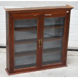 A 20th century glazed two door cabinet with interior shelving and brass handles, width approx 84cm.