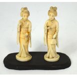 A pair of Japanese Meiji period carved ivory female figures, one carrying a fan,