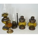 Five various examples of oil lamps to include two matching amber glass lamps (5).