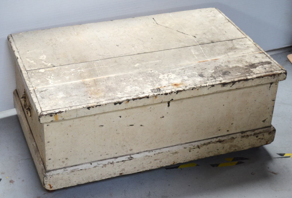 A cream-painted twin iron handle wooden storage box on plinth base, width 85cm (af).