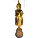 A large 19th century Chinese carved wood and gilded standing figure of Shakyamuni wearing a cloak