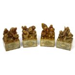 A group of four Chinese carved soapstone scroll weights,