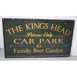 A large green pub sign 'The King's Head - Patrons Only - Car Park and Beer Garden',