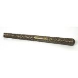 An Indian white metal parasol or cane handle elaborately decorated with foliate scrolls and bearing