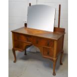A retro walnut kneehole mirror back dressing table with two long drawers over two smaller drawers,