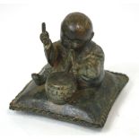 A Chinese bronze figure of a child seated upon a cushion and playing a drum, probably 18th century,