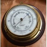 An early 20th century brass ship's barometer with white enamel dial inscribed 'John Barker & Co Ltd,