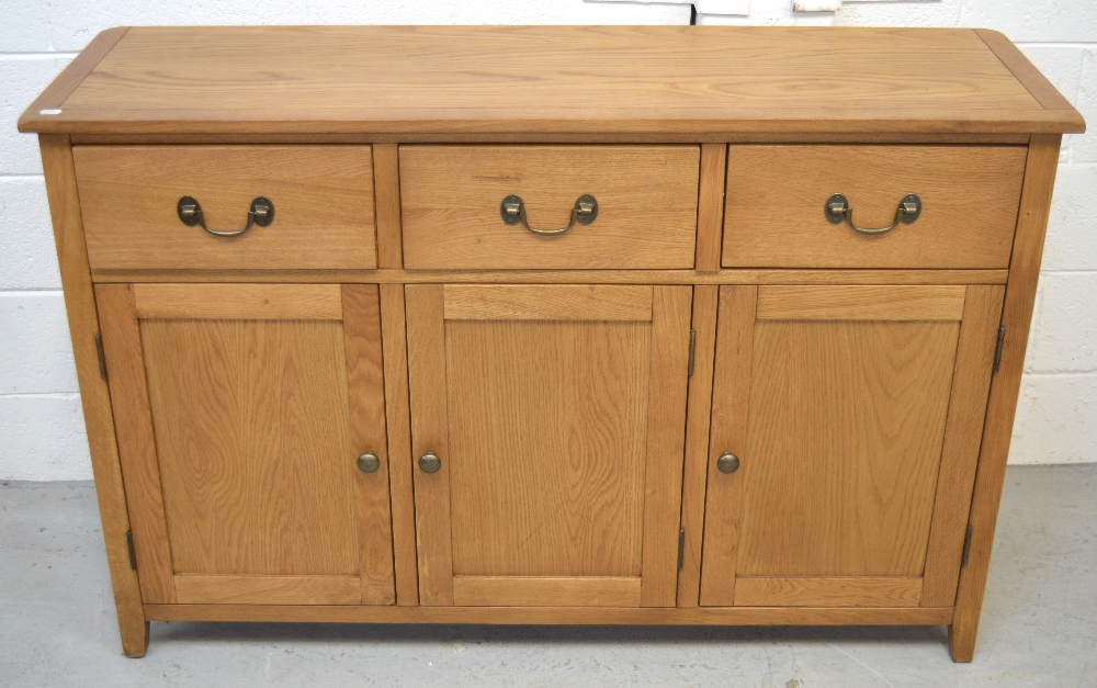 A modern oak sideboard, three drawers over three lower cupboard doors on bracket feet, length 130cm.