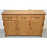 A modern oak sideboard, three drawers over three lower cupboard doors on bracket feet, length 130cm.