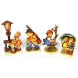 Four Hummel figures to include a young boy and girl sheltering under an umbrella,