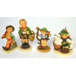 Four Hummel figures to include a young boy carrying a basket, a young boy with umbrella,