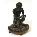 A 19th century Chinese bronze figure of a seated male wearing simple sash cloth on shaped base and