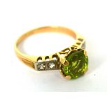 A yellow metal green peridot and diamond chip set dress ring, size J 1/2, approx 2.1g.