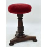 A mahogany circular piano stool on ring turned and carved column to tripartite base with flat bun