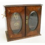 An Edwardian oak two door smoker's cabinet with two small drawers to the interior, width 28.5cm.