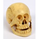 A Japanese Meiji period carved ivory netsuke in the form of a skull, height 3.2cm.