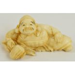 A Japanese Meiji period carved ivory netsuke modelled as a seated man, length 6.5cm.