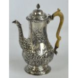 A George III hallmarked silver and later embossed decorated coffee pot with ivory handle,