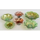 A group of four carnival green glass items comprising three bowls with shaped rims and a candle