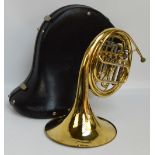 An unbranded brass French horn, cased.