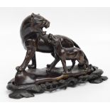 A Japanese bronze figure group depicting a lioness with a cub, on shaped oval base, length 20.5cm.
