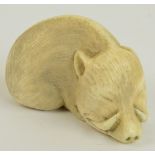 A Japanese Meiji period carved ivory netsuke modelled as a sleeping boar, length 4.5cm.